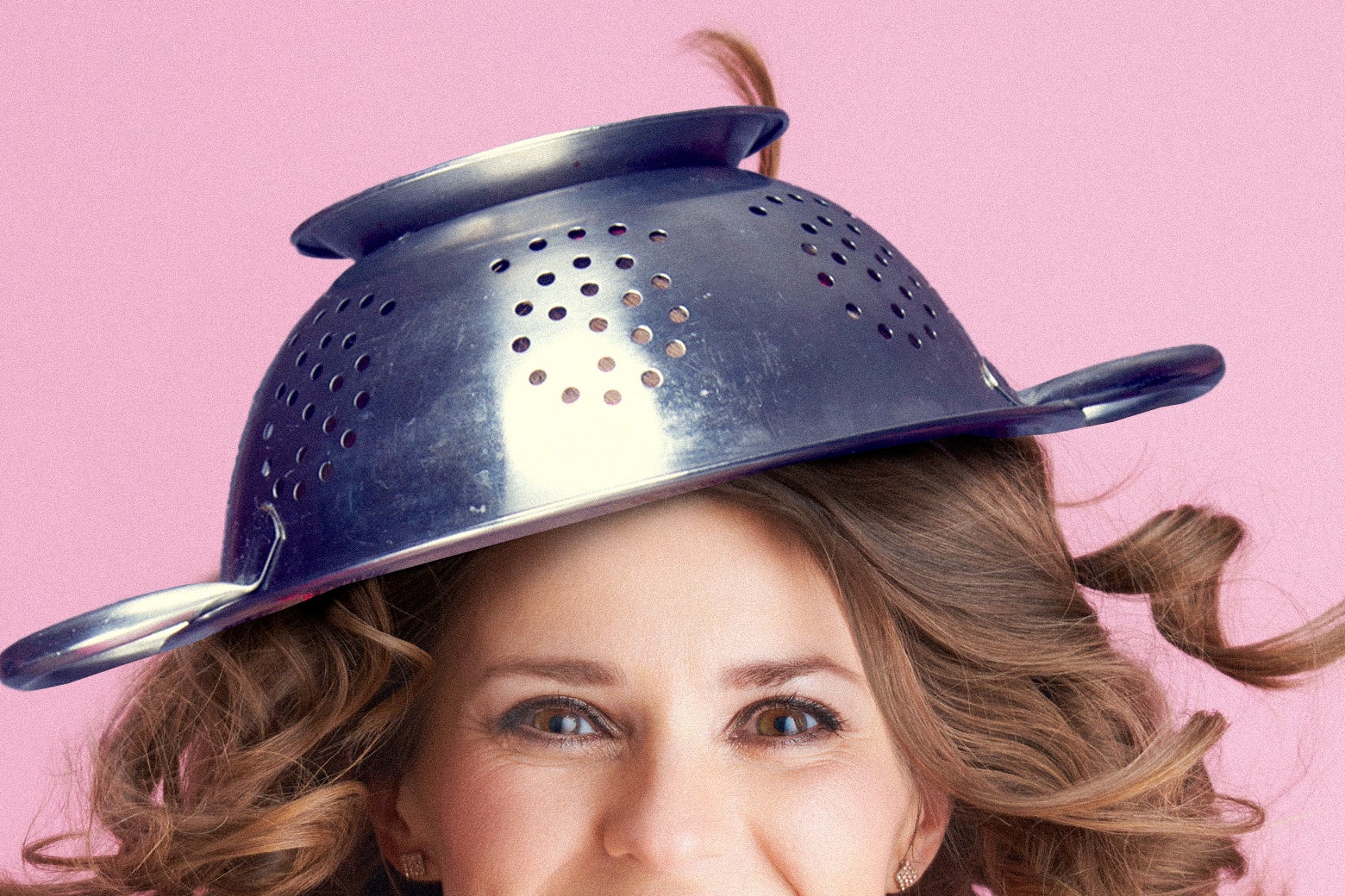 A woman wearing a pasta strainer on her head.