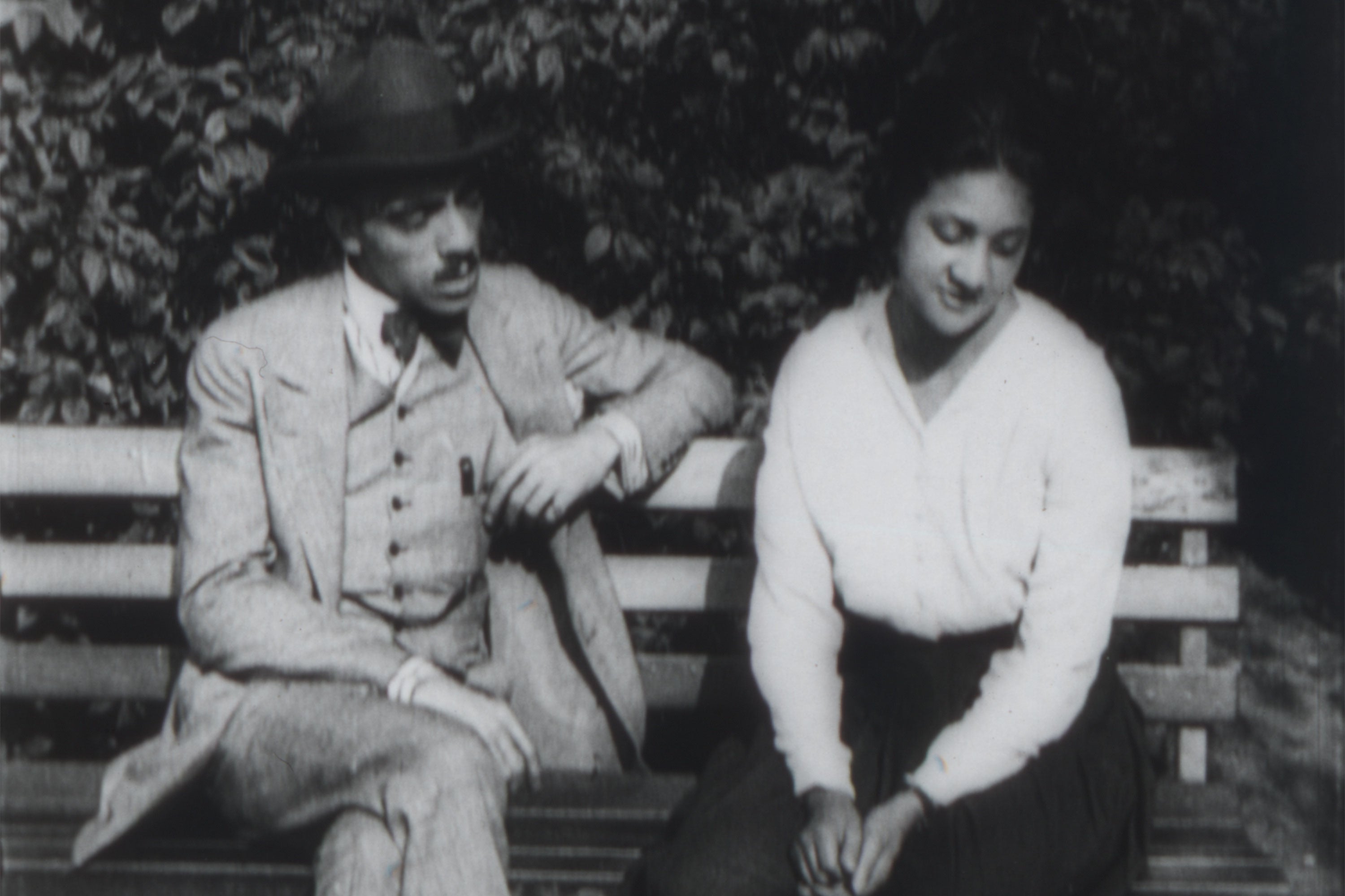 Black and white image of a couple on a bench.