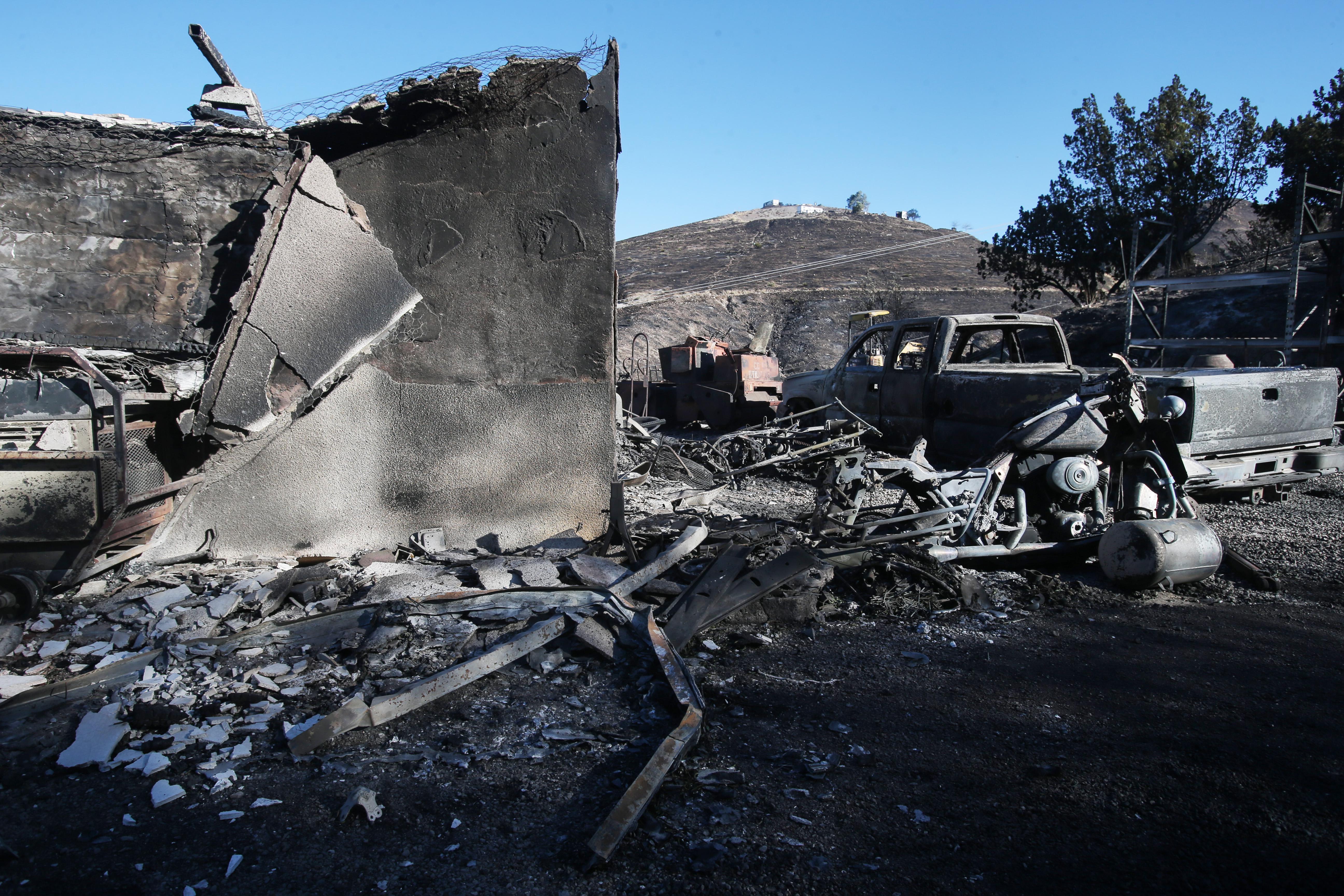 A structure and vehicle stand scorched by the Tick Fire on Friday in Canyon Country, California.