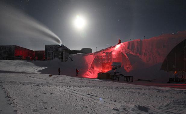 South Pole employees remove snow from the top of buildings during the winter darkness, on May 9, 2012.