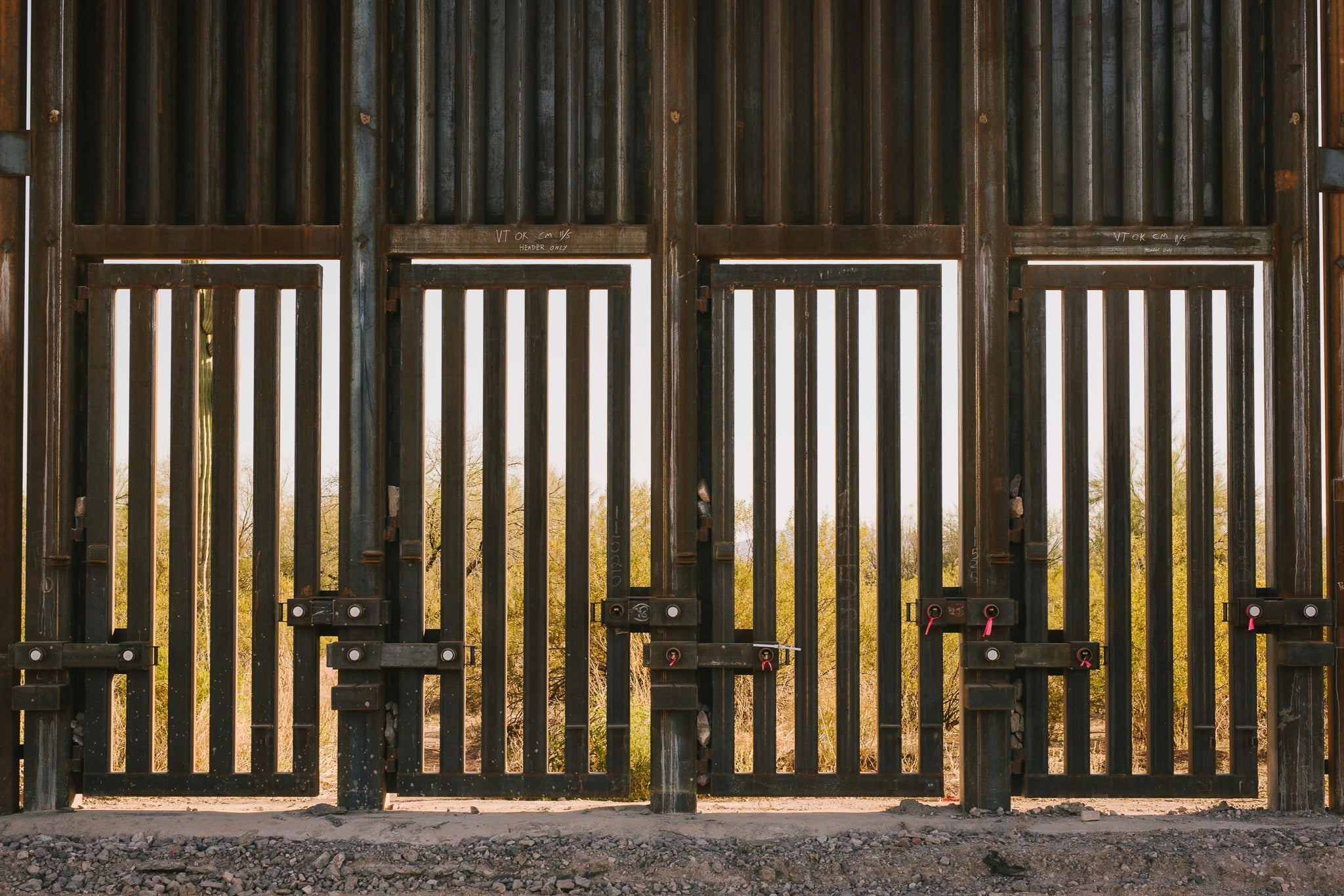 "Doors" with open metal slats at the bottom of a fence.
