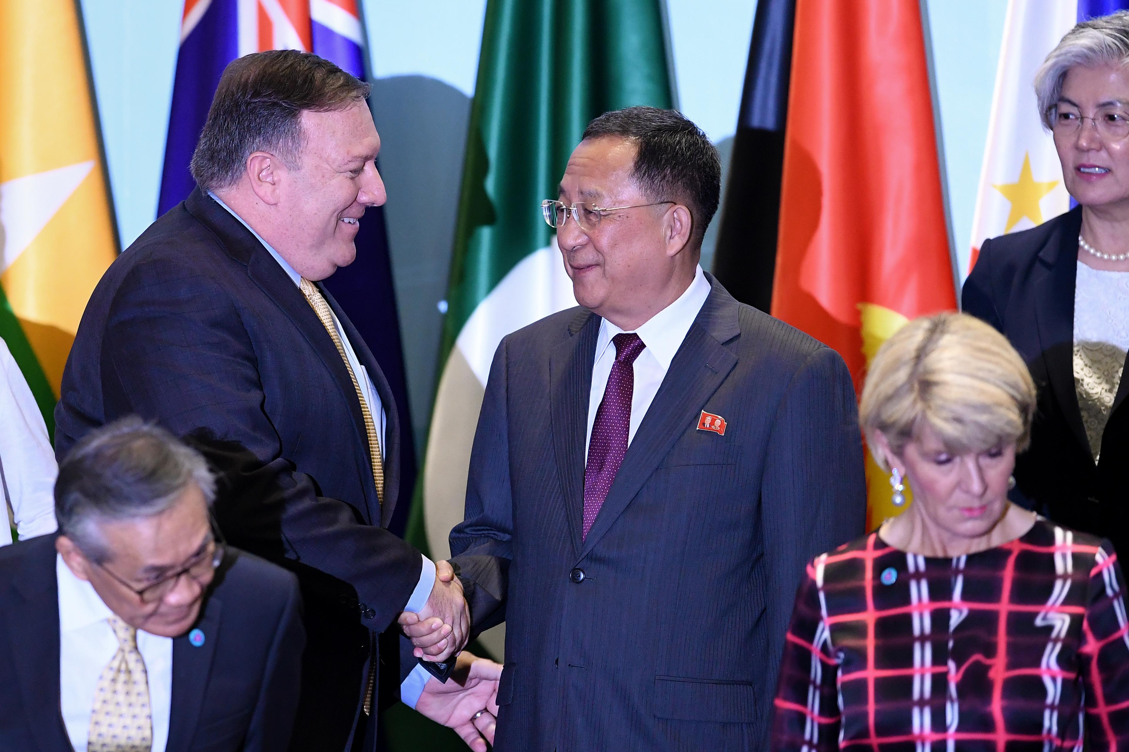 Secretary of State Mike Pompeo (top L) shakes hands with North Korea's Foreign Minister Ri Yong Ho (C) as South Korea's Foreign Minister Kang Kyung-wha (top R) looks on, as they arrive for a group photo at the ASEAN Regional Forum Retreat during the 51st Association of Southeast Asian Nations (ASEAN) Ministerial Meeting (AMM) in Singapore on August 4, 2018.