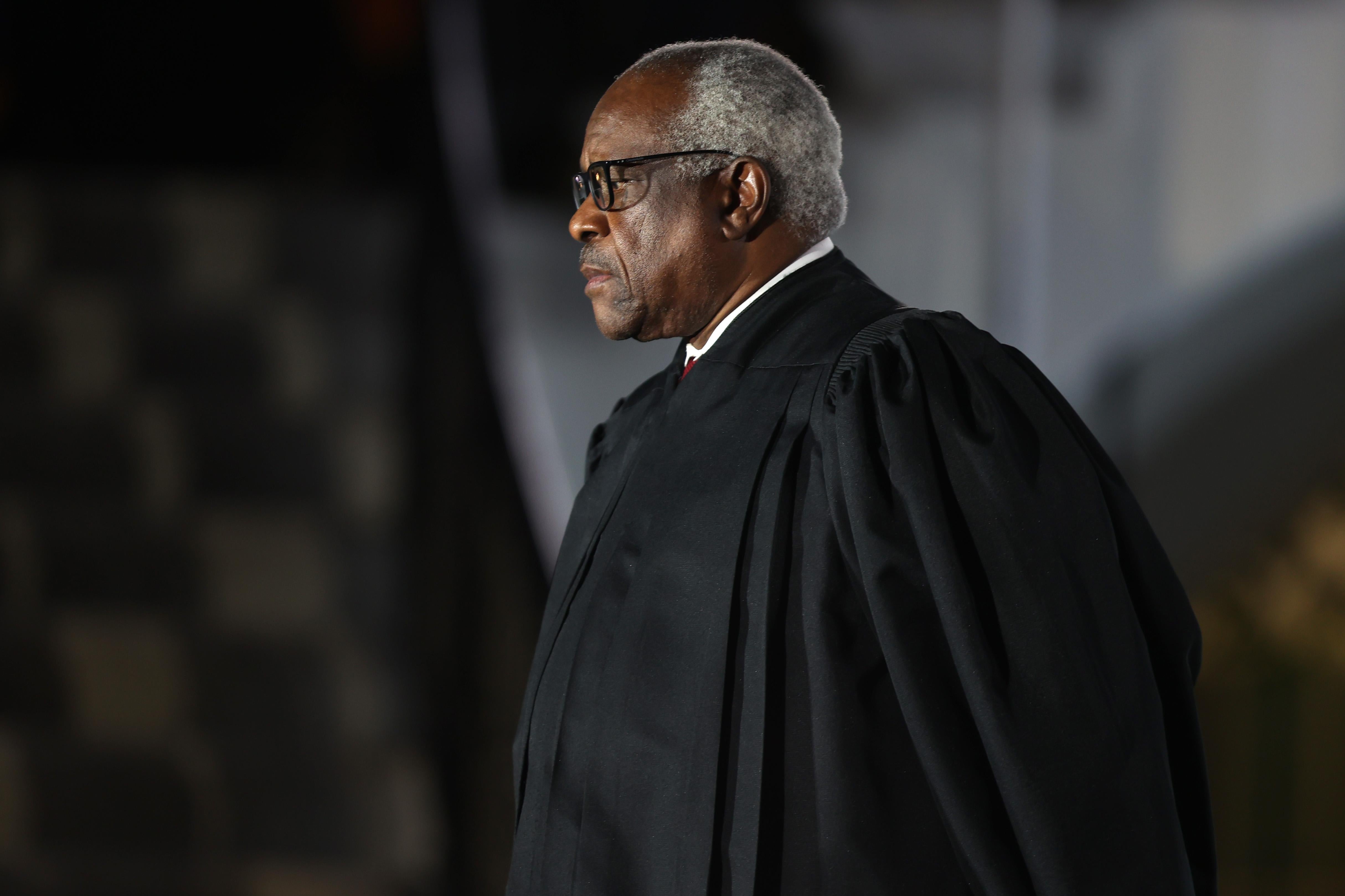 Clarence Thomas wearing his robe and looking serious.
