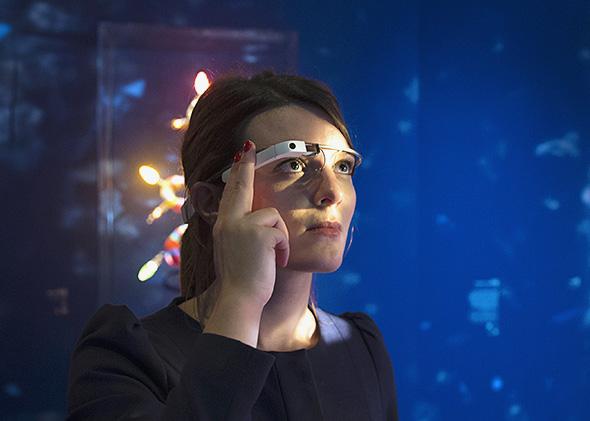 A woman wears Google glass.