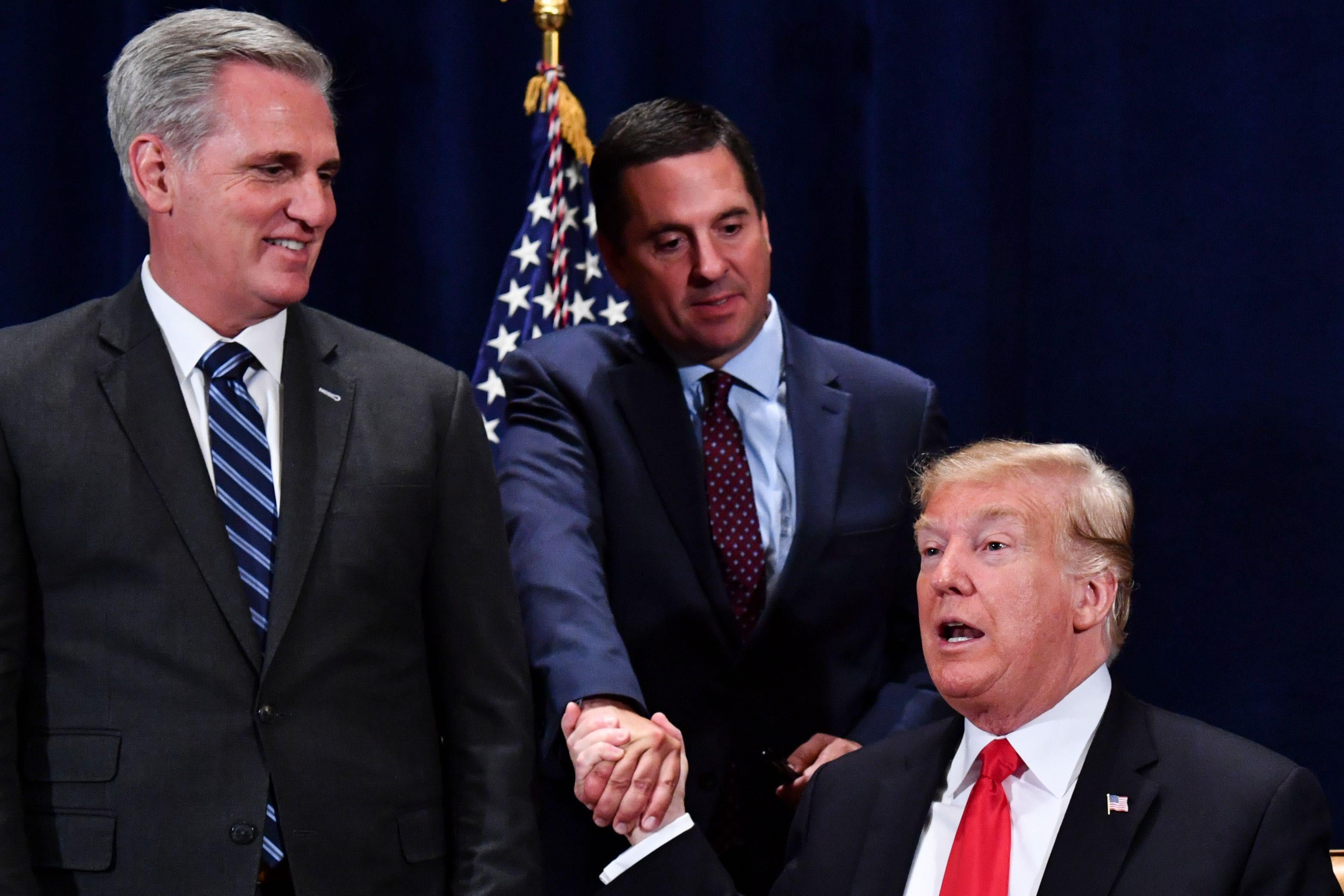 President Trump shakes hands with Rep. Devin Nunes as then-House Majority Leader Kevin McCarthy looks on Oct. 19, 2018.
