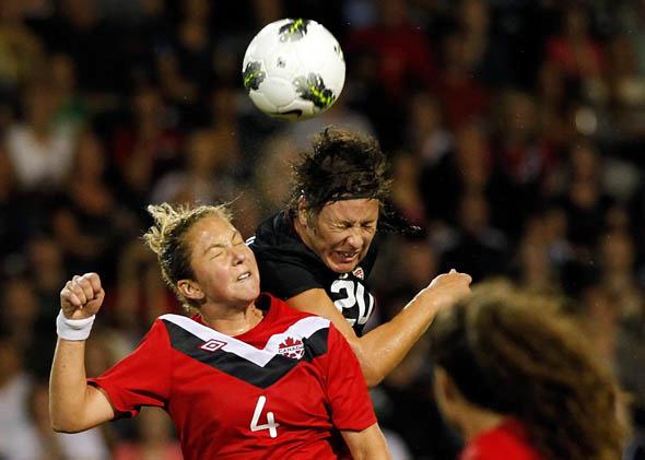 Abby Wambach #20 of the United States heads the ball against Carmelina Moscato #4 of Canada in September 2011 in Portland, Oregon.