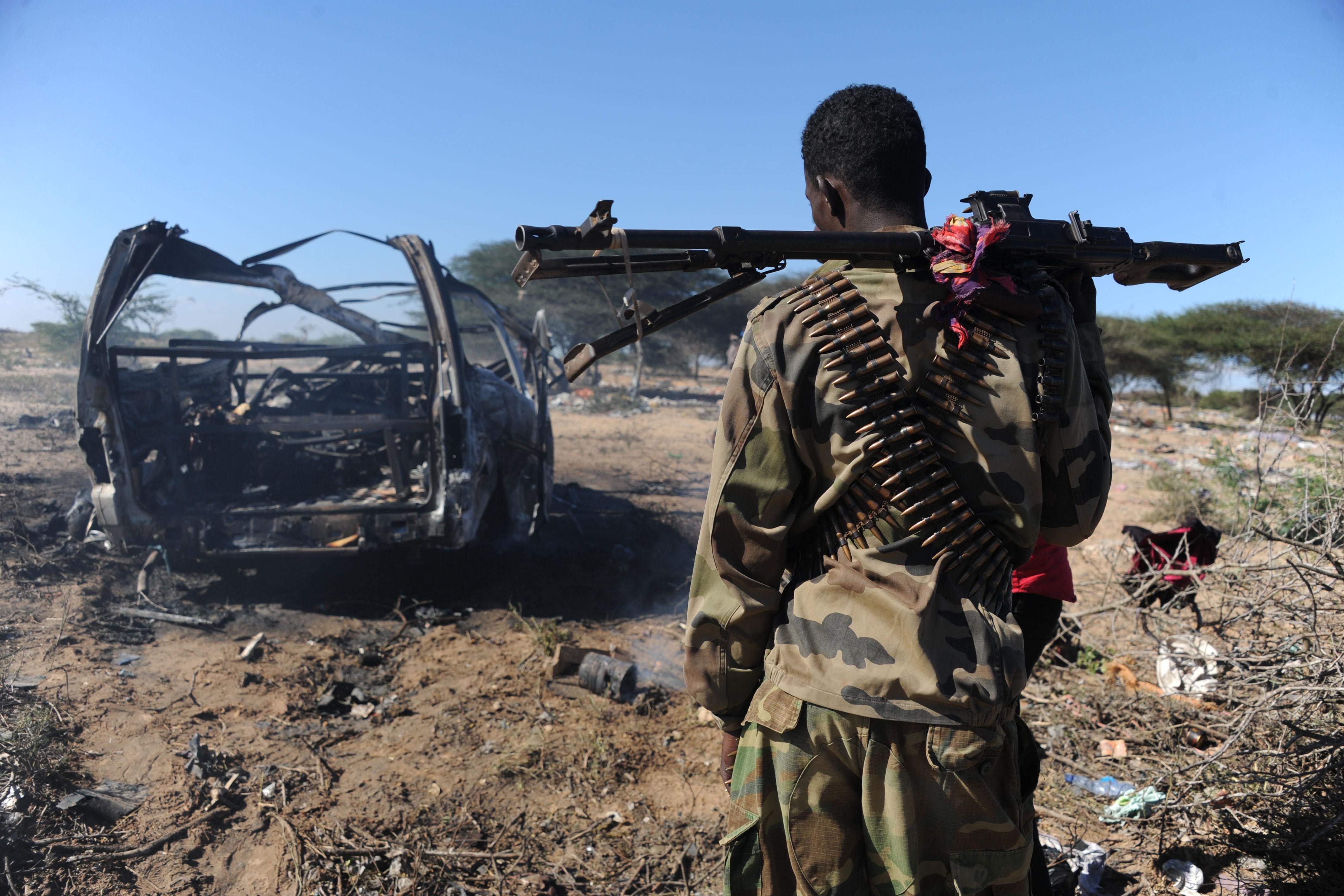 A soldiers checks the area where a suicide bomber from Somalia's Shebab insurgents killed at least 12 people and wounded 27 others, on September 8, 2014, by ramming a vehicle packed with explosives into a convoy of African Union troops in Mogadishu. The attack, the latest in a string of killings, comes exactly one week after a US airstrike killed the chief of the Al-Qaeda-linked Shebab rebels, Ahmed Abdi Godane, prompting threats of retaliation from the extremists.    AFP PHOTO MOHAMED ABDIWAHAB        (Photo credit should read Mohamed Abdiwahab/AFP via Getty Images)