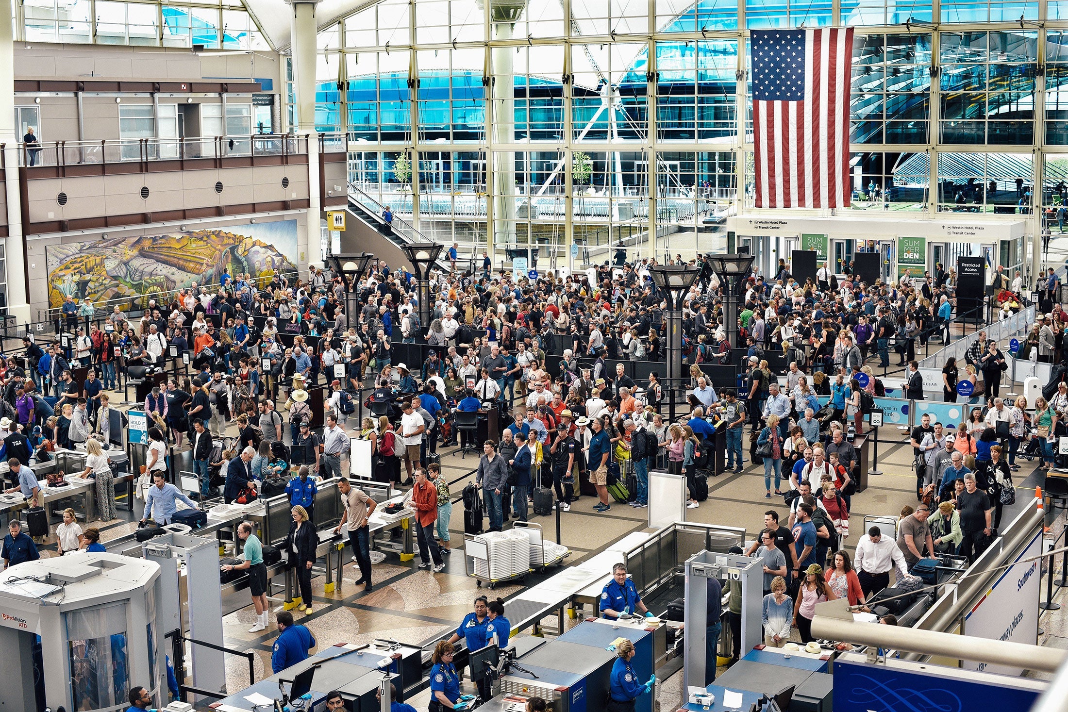 A long line of passengers wait to enter security screening at an airport.