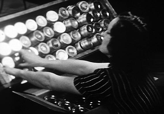 An unnamed worker attaches lids onto boxfuls of canning jars in a still image taken from the 1920s Frank Gilbreth research film.