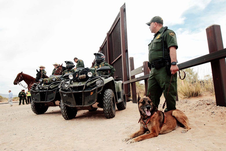 Border Patrol agents on horses and ATVs, as well as a guard on foot with a dog, at the Southern border.