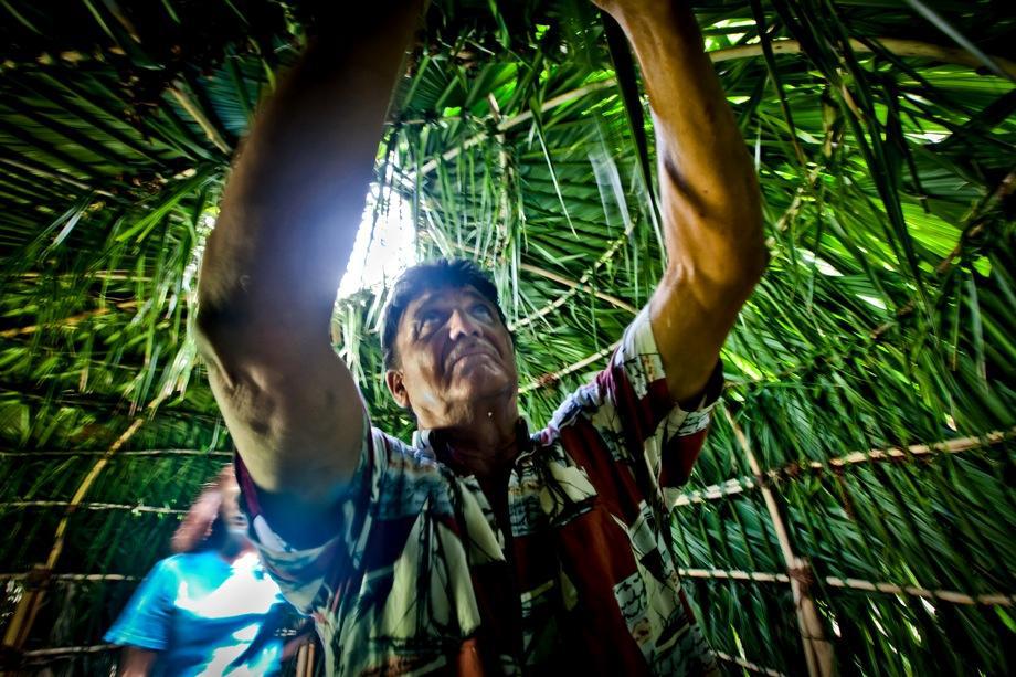 Jake Billiot, a member of the Pointe-aux-Chien tribe, works on a Palmetto hut built during a summer camp session for the tribe's children to expose them to their disappearing culture.