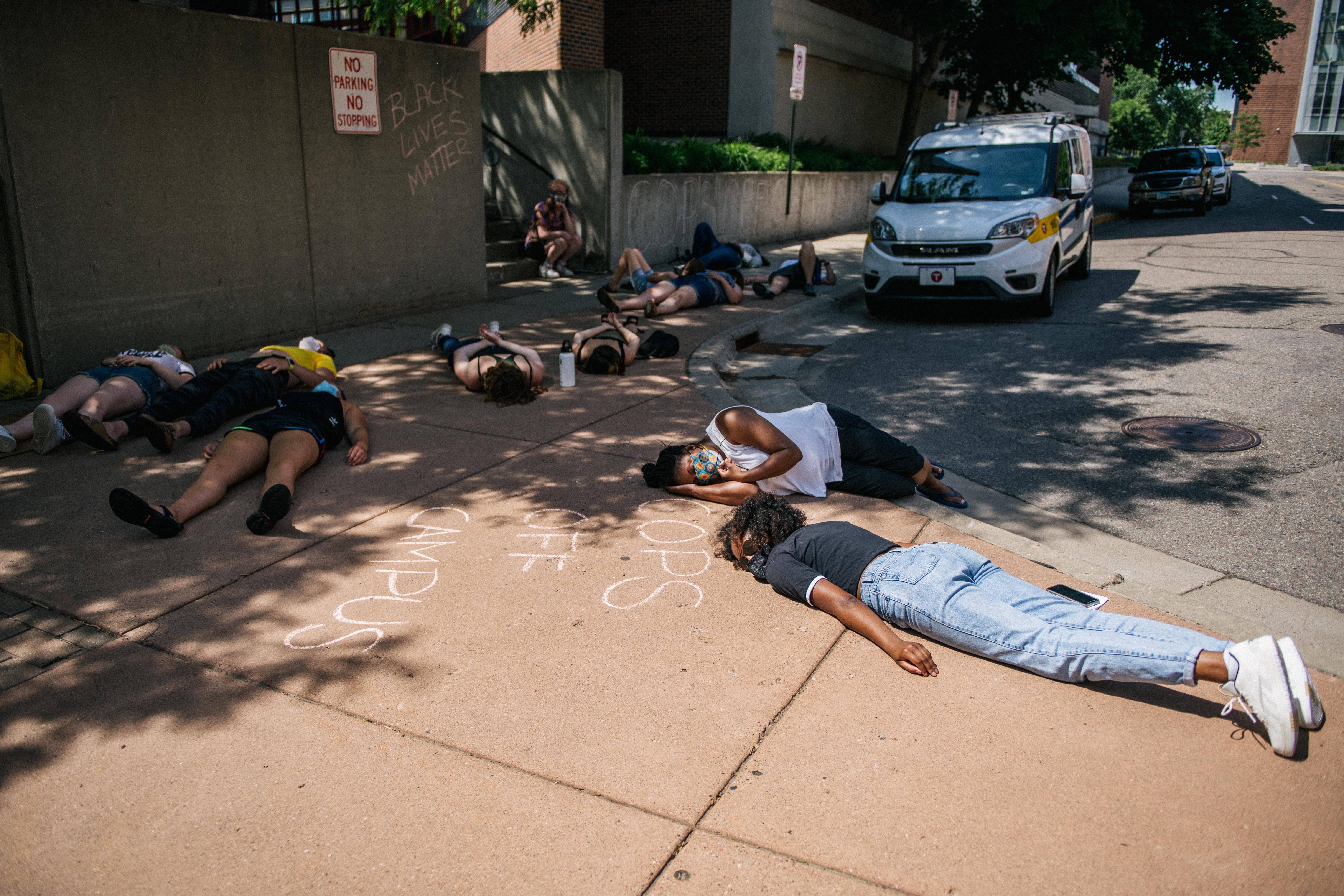 College students lying prostrate on a sidewalk in protest.