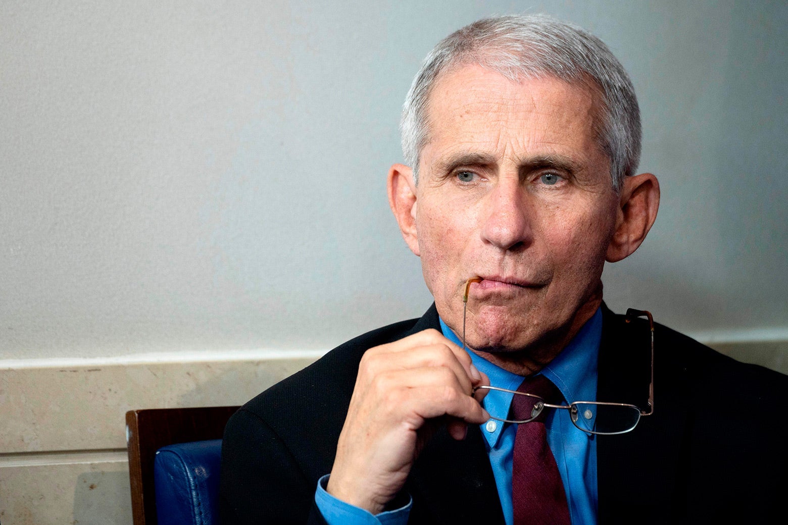 Anthony Fauci chews on one end of his glasses.