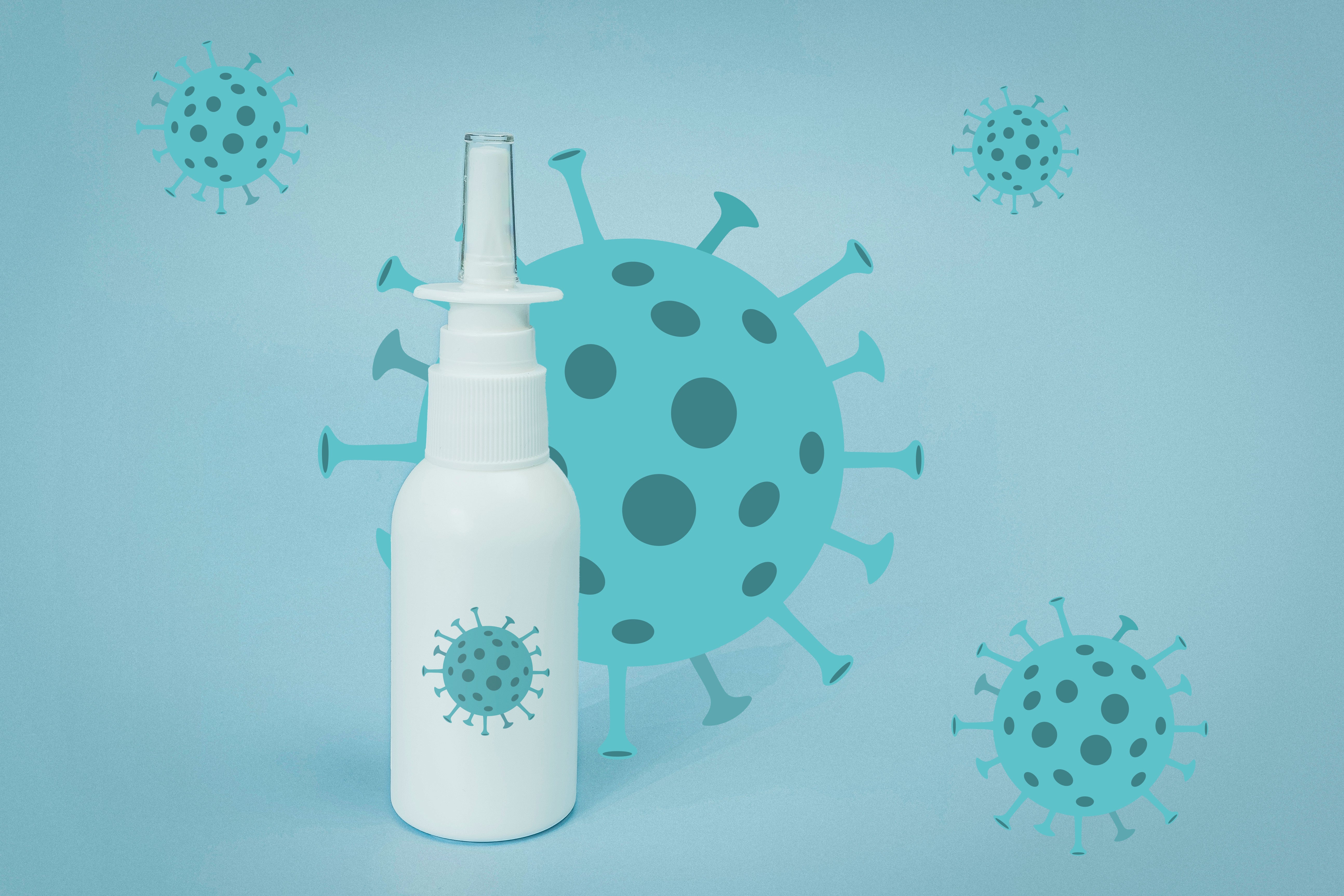 A nasal spray bottle in front of a COVID virus particle.