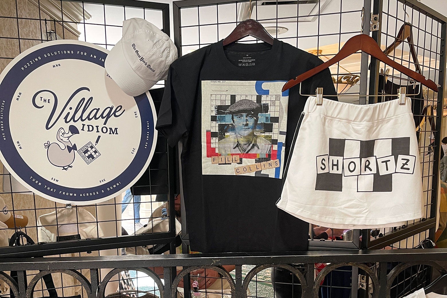 A selection of merch, including crossword-patterned white shorts that read "Shortz" and a T-shirt that says "Fill Collins."