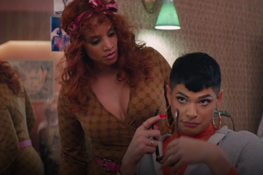 Dascha Polanco stands over Valentina, who looks up while holding a pair of sunglasses.