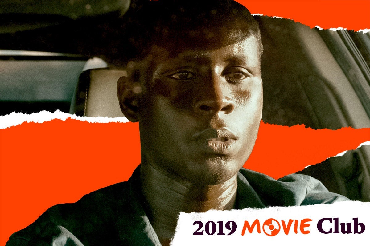 A man stairs straight ahead in a car. Text in the corner says, "2019 Movie Club."