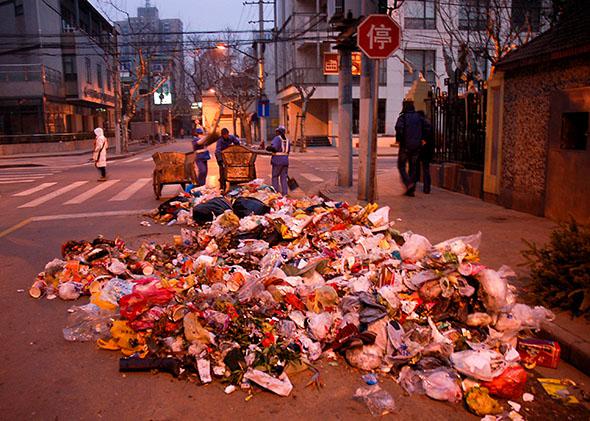 Garbage is strewn on the street as public workers collect it, Sh