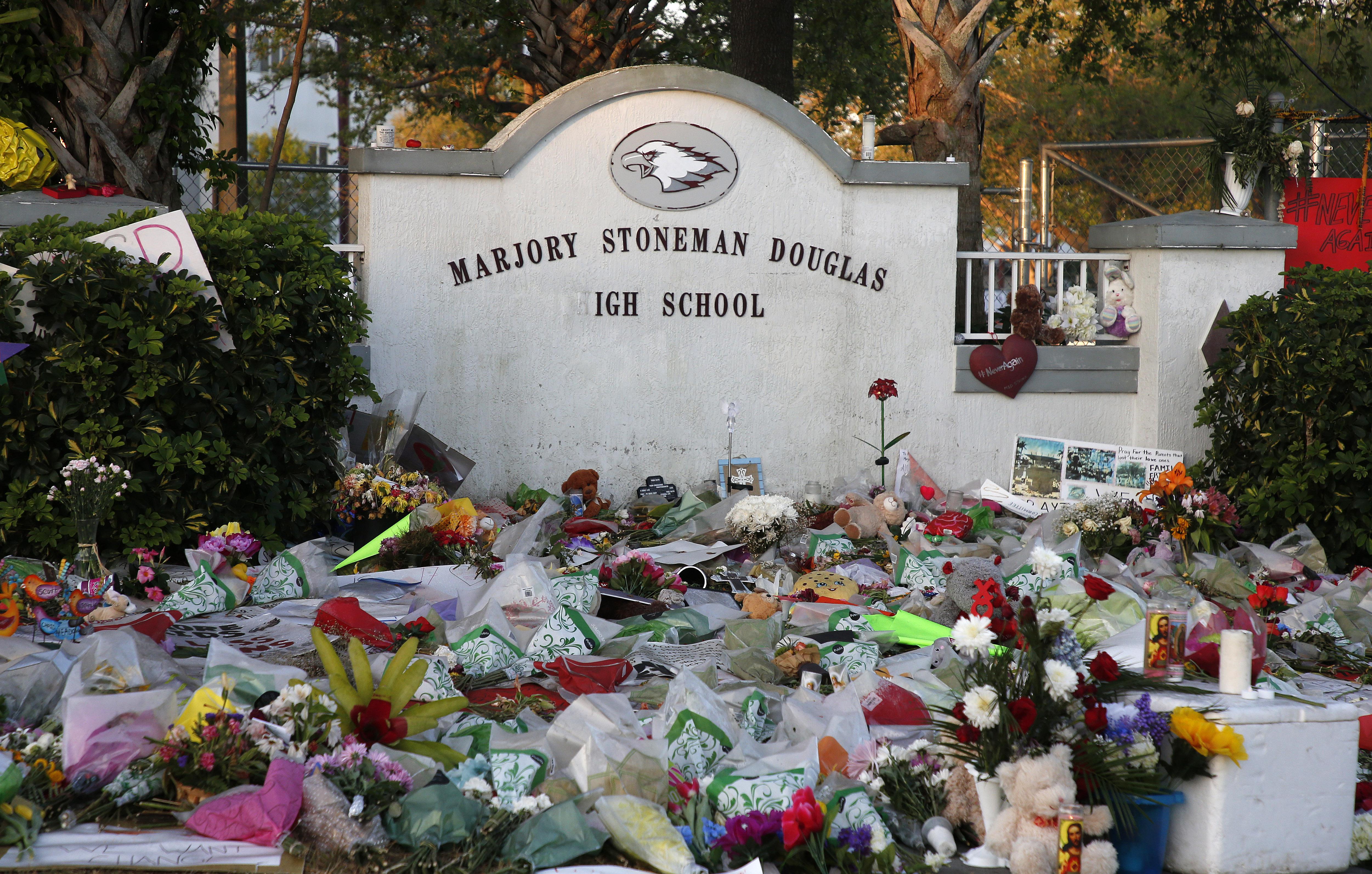 Flowers, candles and mementos sit outside one of the makeshift memorials at Marjory Stoneman Douglas High School in Parkland, Florida on February 27, 2018.