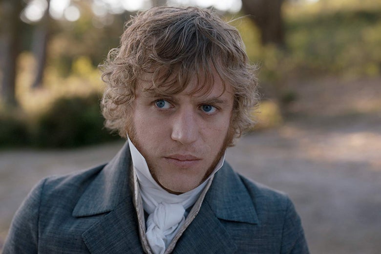 Johnny Flynn wears a navy coat with a cravat.