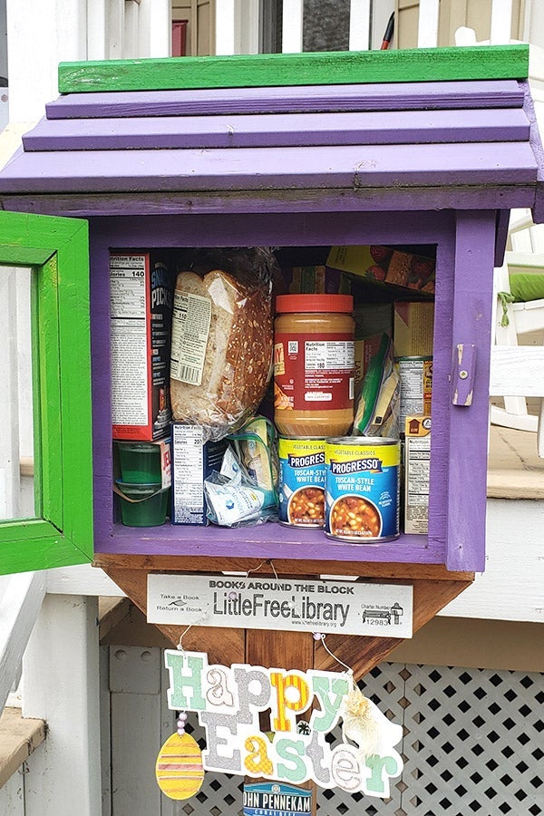 A Little Free Library filled with bread, peanut butter, and canned soup.