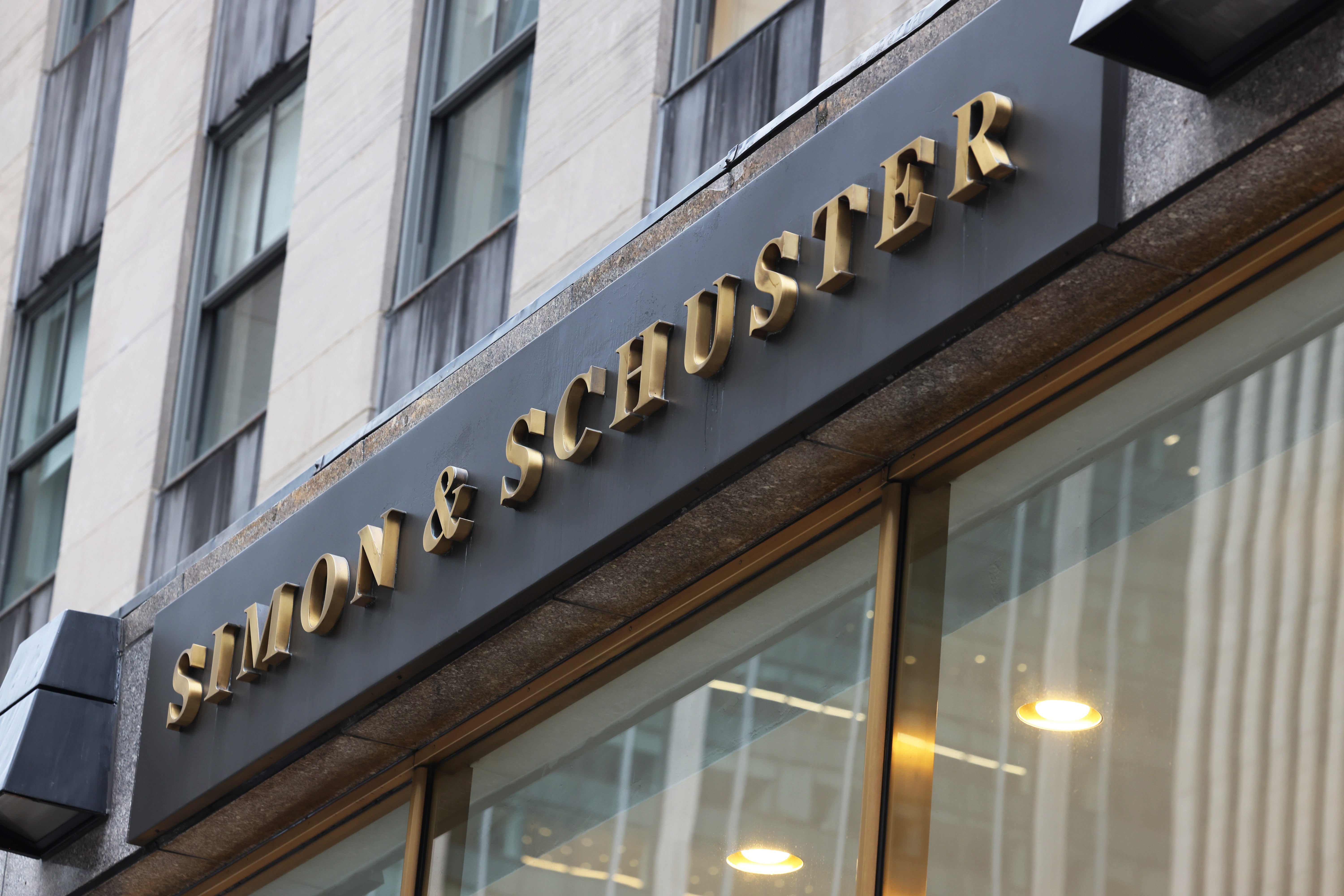 The gold-lettered sign of Simon & Schuster headquarters is seen from an angle.