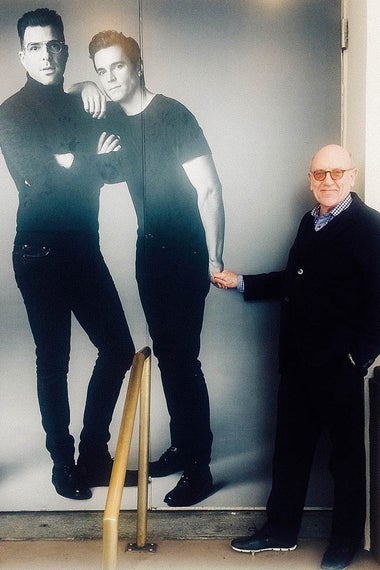 Playwright Mart Crowley in front a poster of The Boys in the Band stars Zachary Quinto and Matt Bomer.