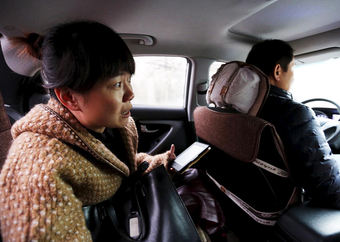 Yoko Wu instructs an Uber taxi driver en route to her office in Beijing, China, November 18, 2015. Yoko lives in the Beijing suburbs with her family and children. 