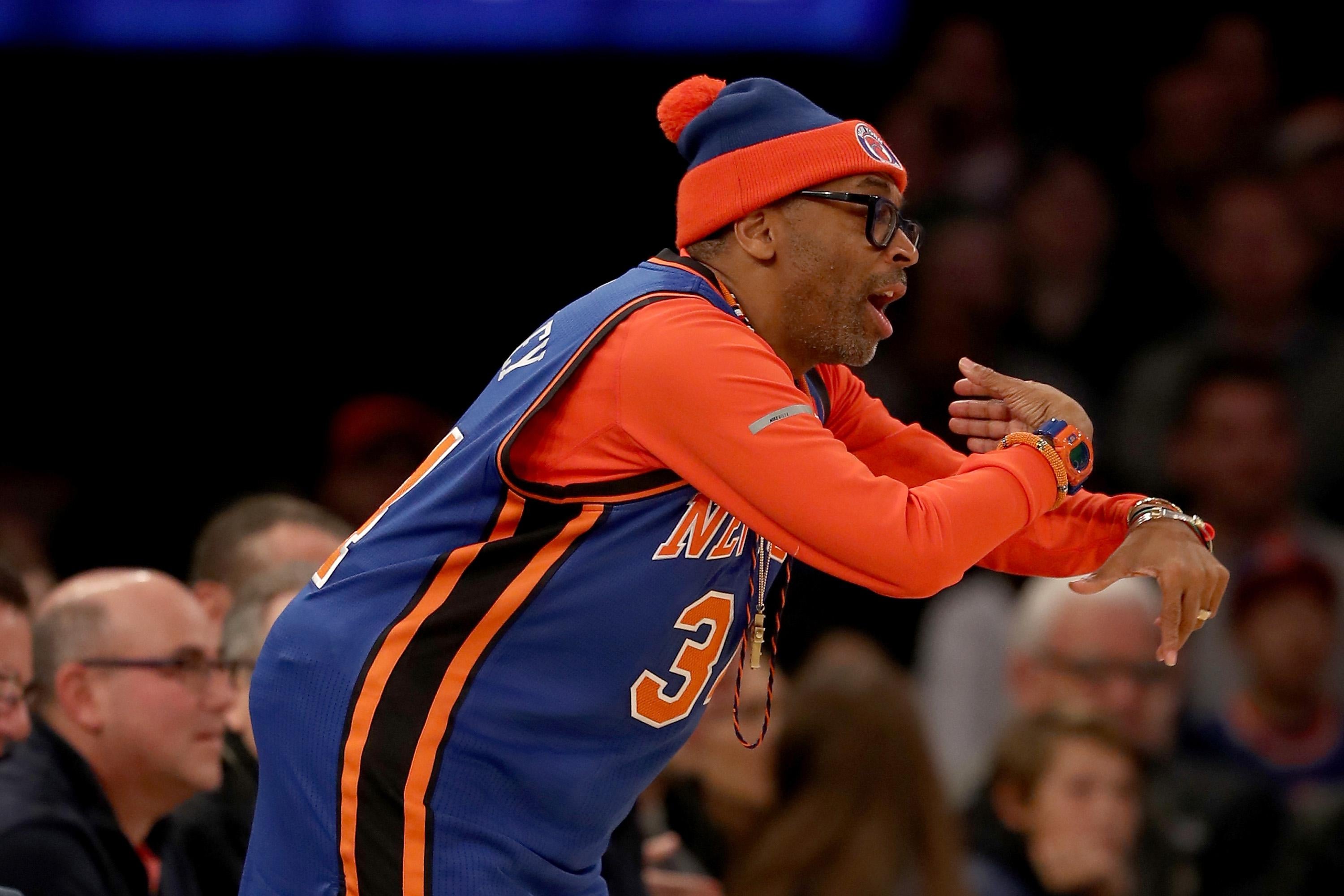 Spike Lee wearing a Knicks jersey, gesturing courtside at a game between the New York Knicks and the San Antonio Spurs in New York on Feb. 12, 2017.
