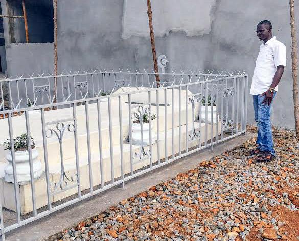 Mohamed SK Sesay standing by the grave of the late Dr. Khan, who