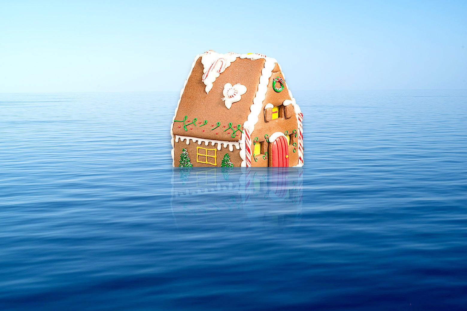 A gingerbread house floating in the middle of the ocean.