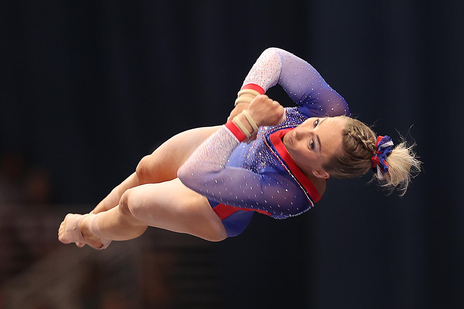 MyKayla Skinner flipping horizontally through the air, her legs and arms tucked tightly together, in a line with her torso