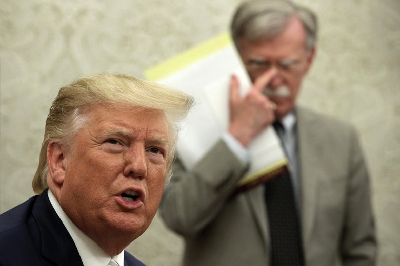President Donald Trump speaks to members of the media as then-National Security Adviser John Bolton listens during a meeting with President of Romania Klaus Iohannis in the Oval Office of the White House on August 20, 2019 in Washington, D.C.