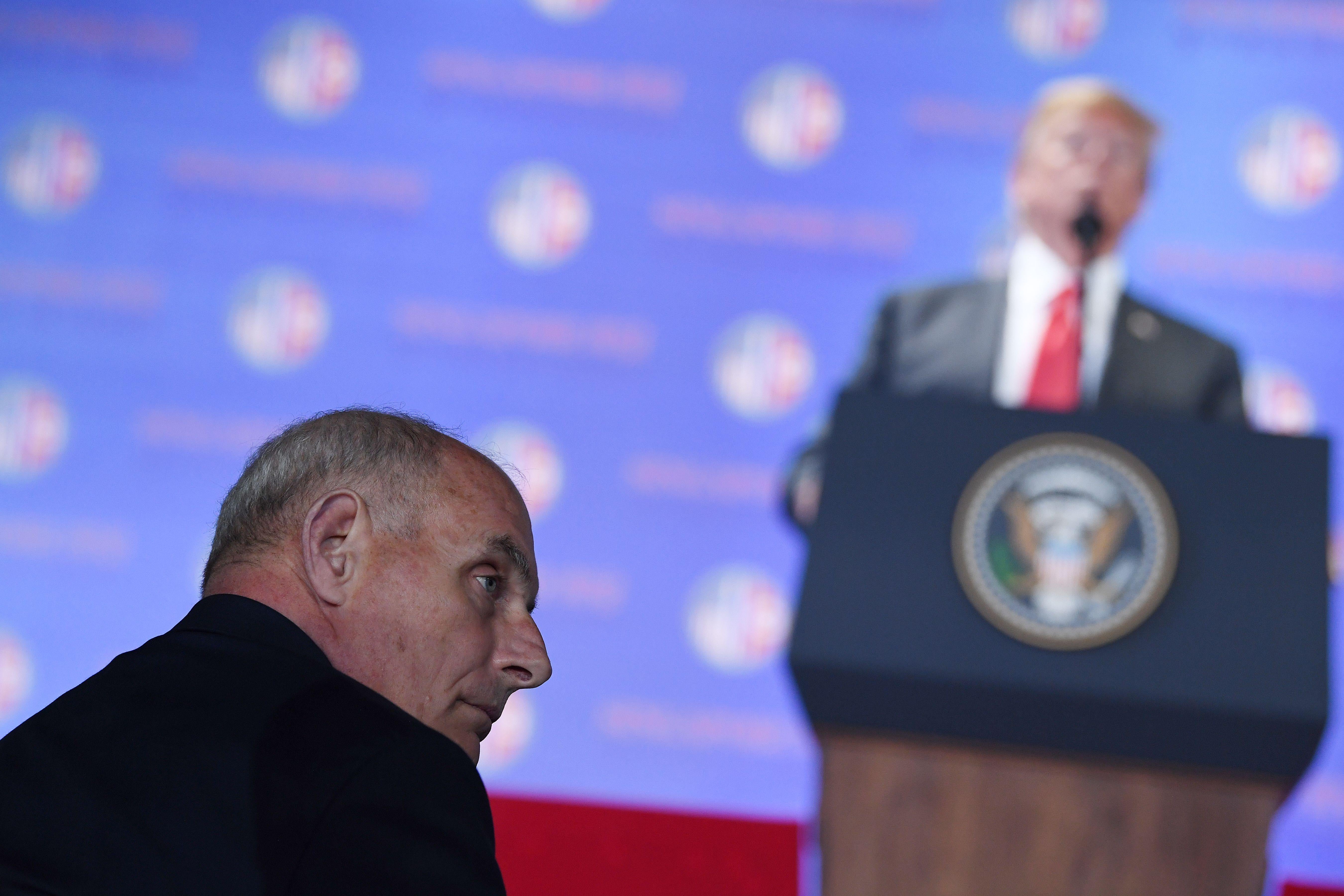 White House Chief of Staff John Kelly listens to US President Donald Trump speak during a press conference following the historic US-North Korea summit in Singapore on June 12, 2018. - Trump and North Korean leader Kim Jong Un hailed their historic summit on June 12 as a breakthrough in relations between Cold War foes, but the agreement they produced was short on details about the key issue of Pyongyang's nuclear weapons.