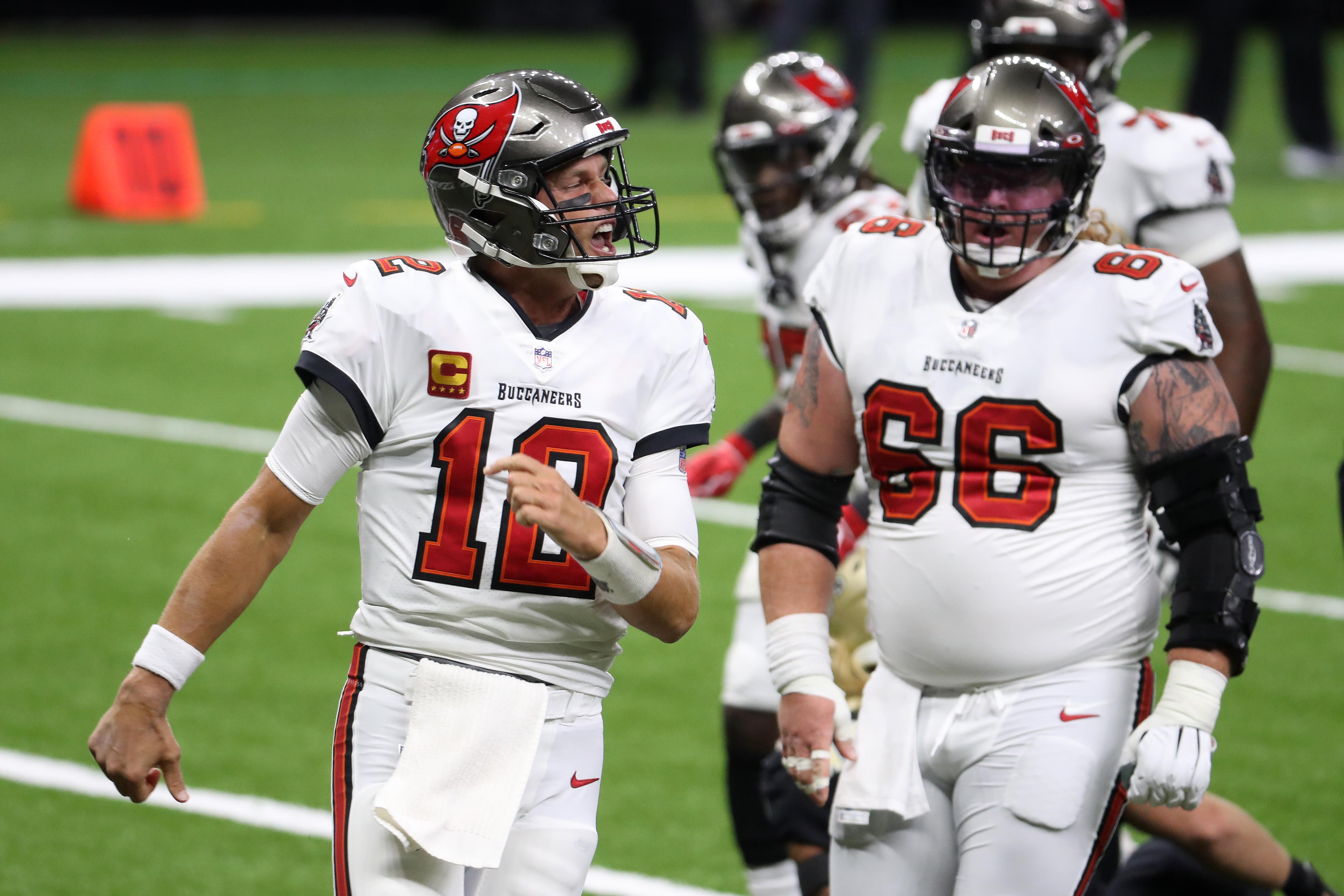 Tom Brady, walking on the field with his Bucs teammates, celebrates a touchdown