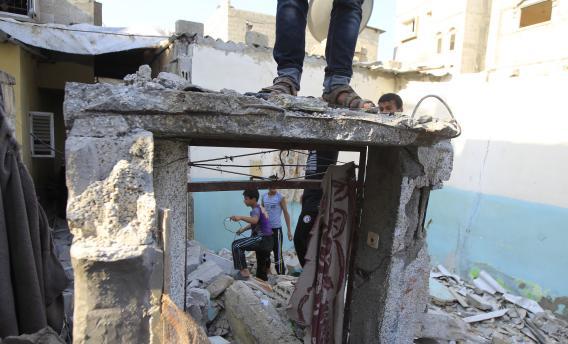 Palestinian boys amid the rubble of a damaged house targeted by an overnight Israeli air strike in the southern Gaza Strip.