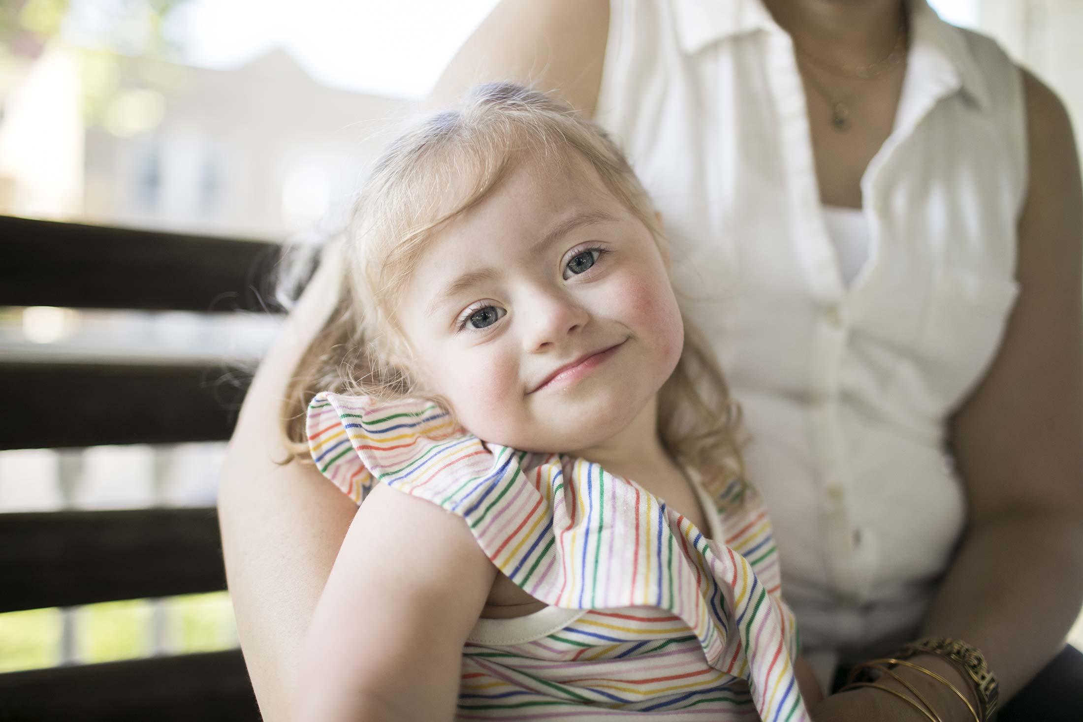 Clementine sits on her mom’s lap on the porch at their home.