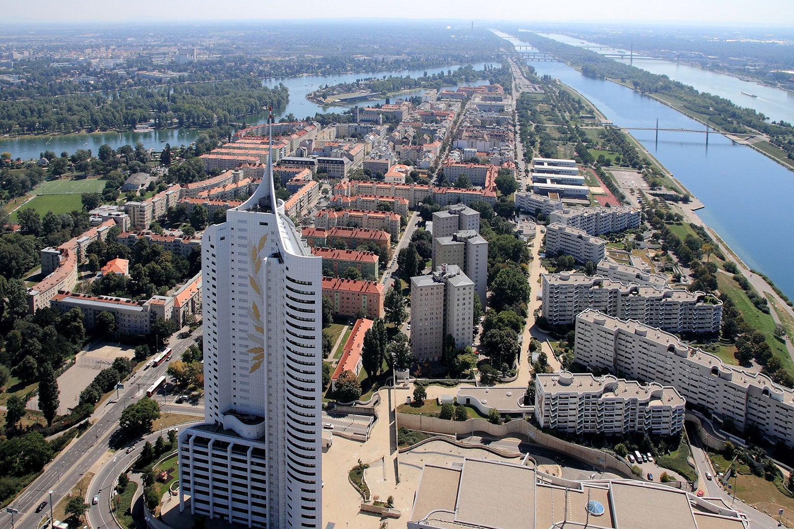 A modern-looking, large housing project, along the Danube River, seen from above.