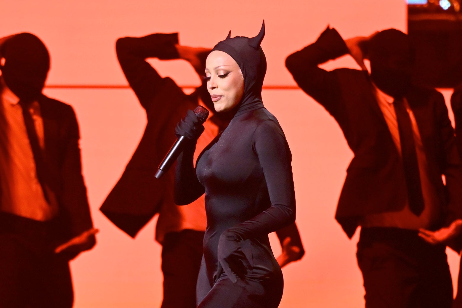 Doja Cat dressed as a devil performing onstage.