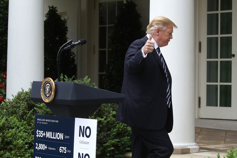 Trump gives a thumbs up while walking away from a lectern toward the White House.