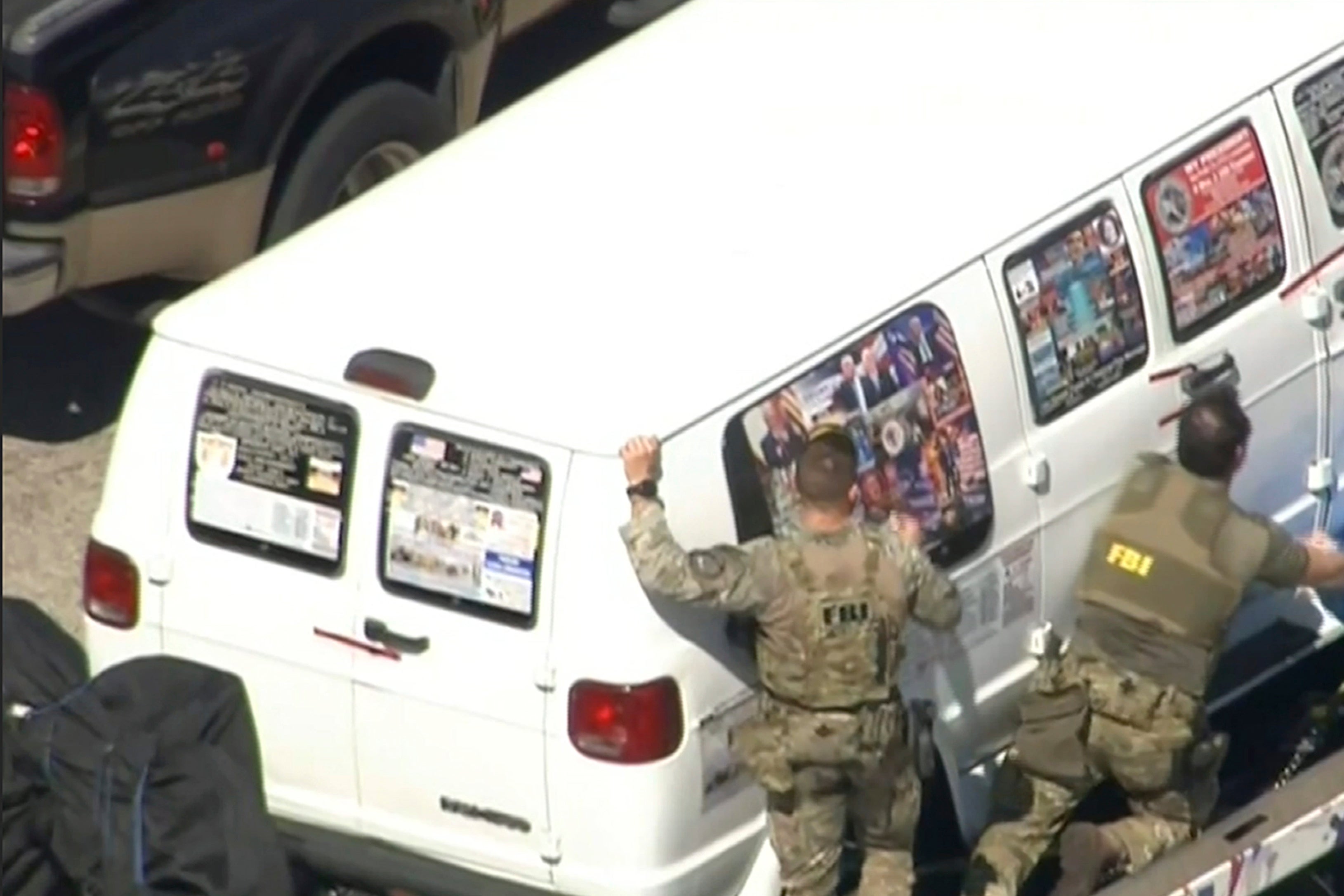 FBI agents covering a van after the tarp fell off.