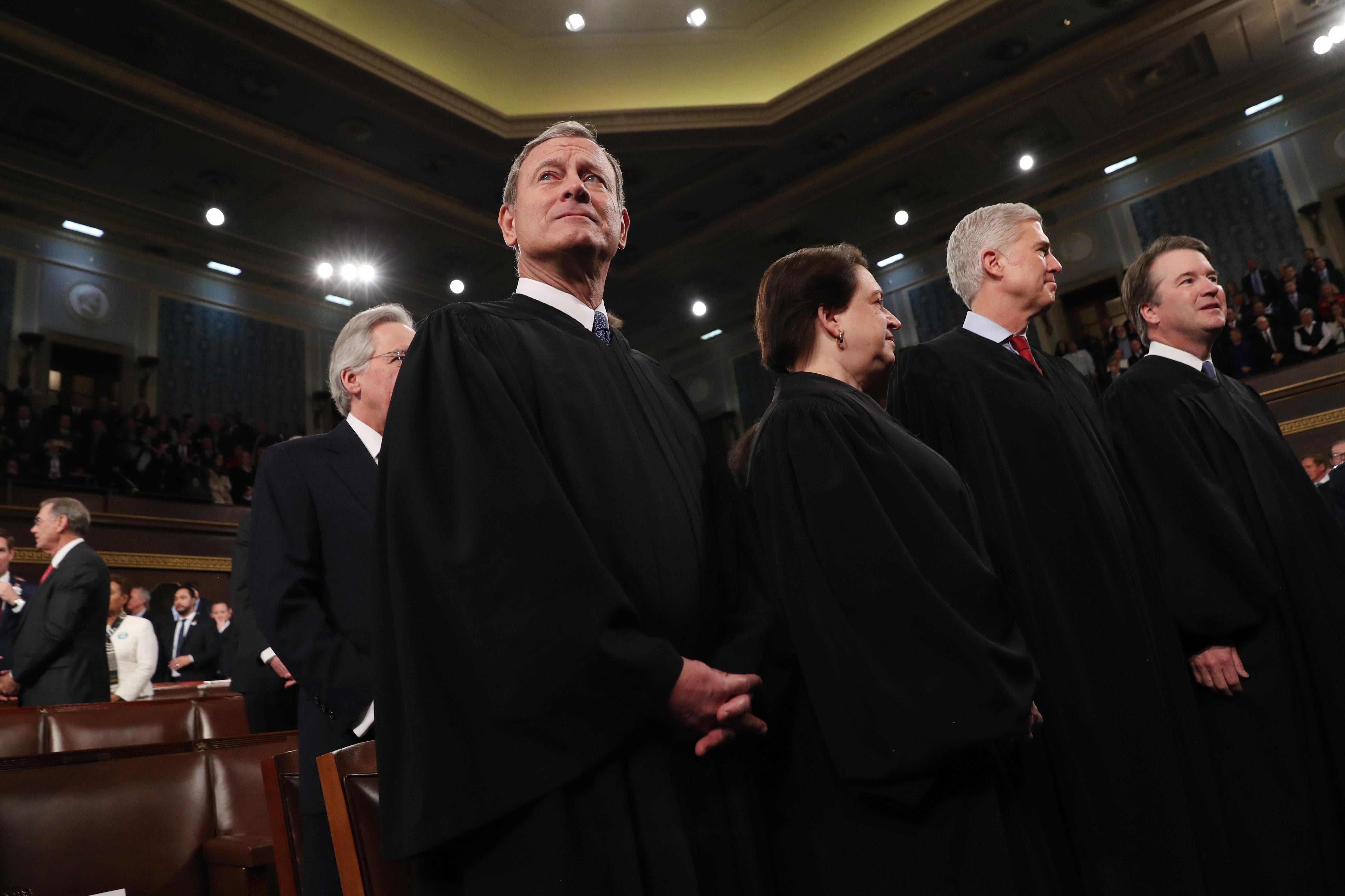 Chief Justice John Roberts stands next to Elena Kagan, Neil Gorsuch, and Brett Kavanaugh.