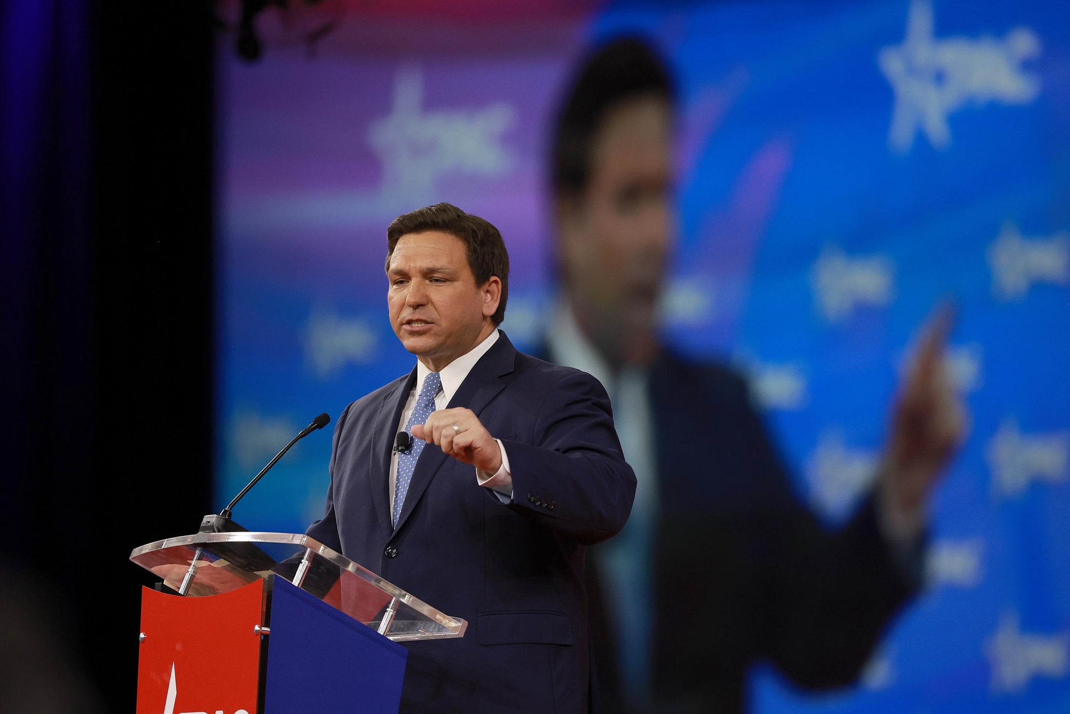 Ron DeSantis gestures as he speaks at a podium onstage