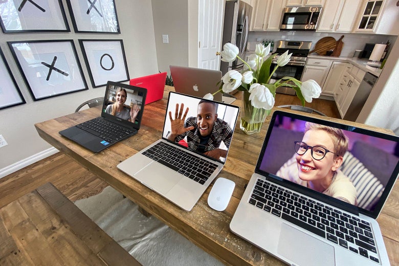 Screens with faces on them, sitting on a table.