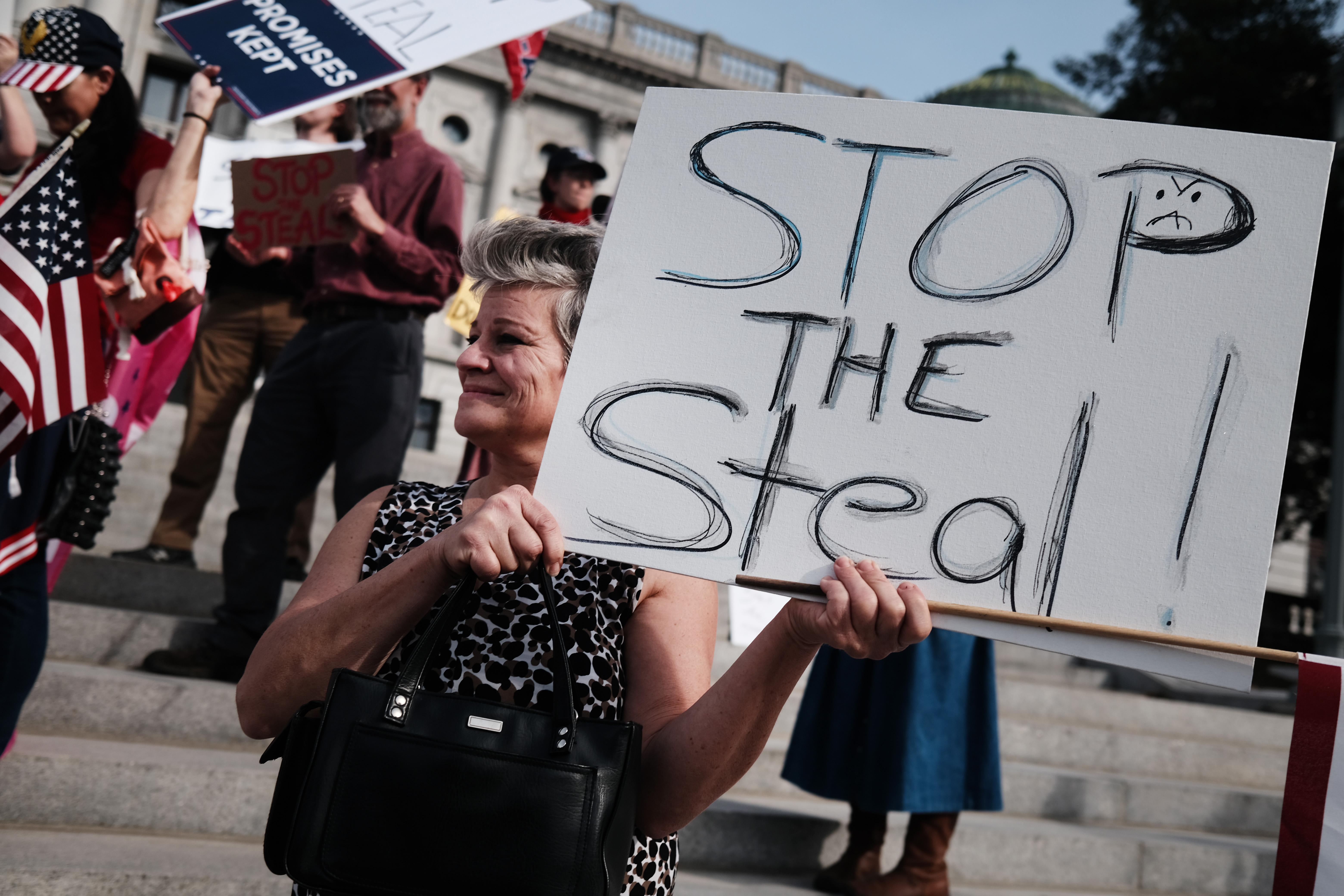 A protester holds a "Stop the Steal" sign at the Pennsylvania state capital.