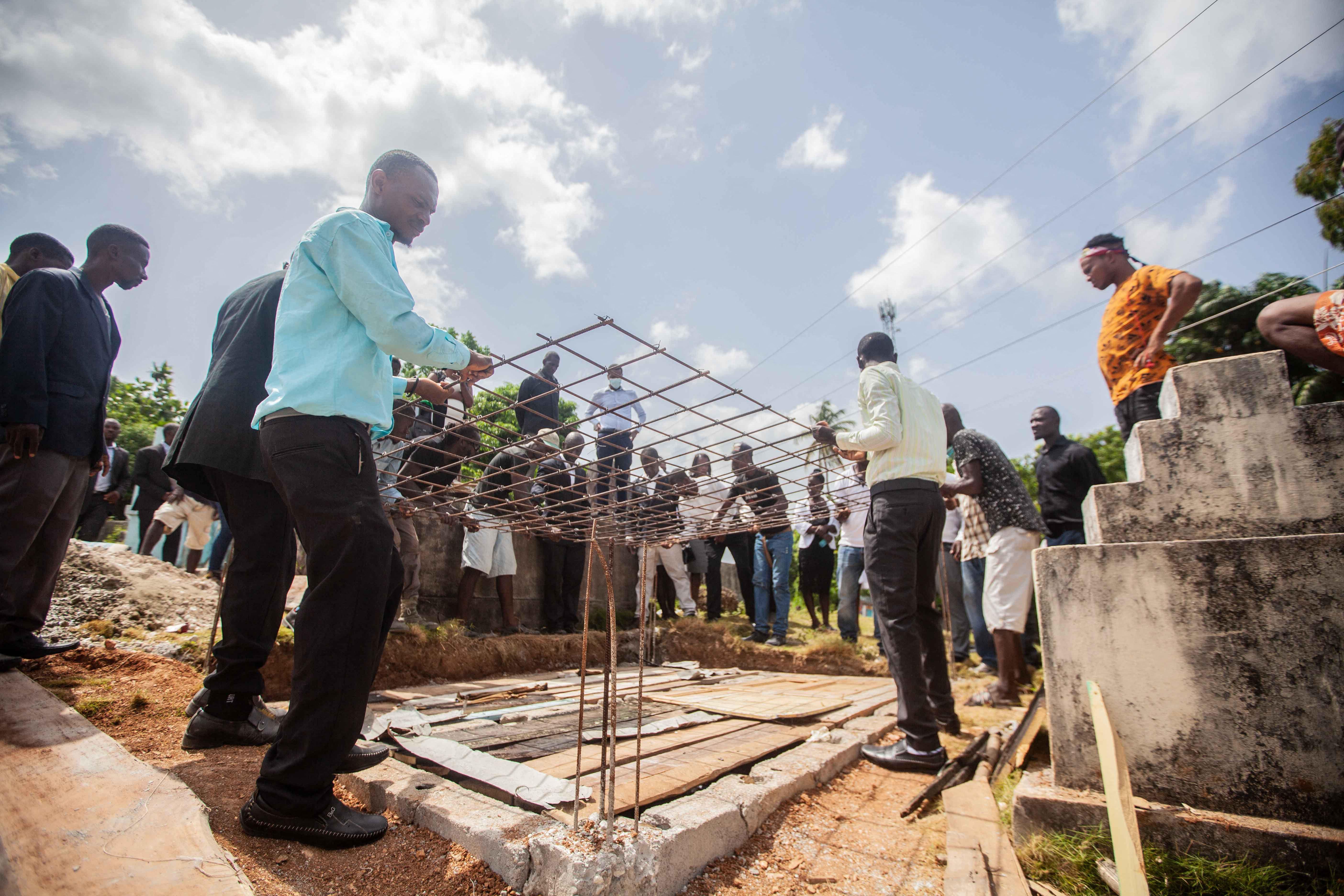 Haitians work on rebuilding a school.