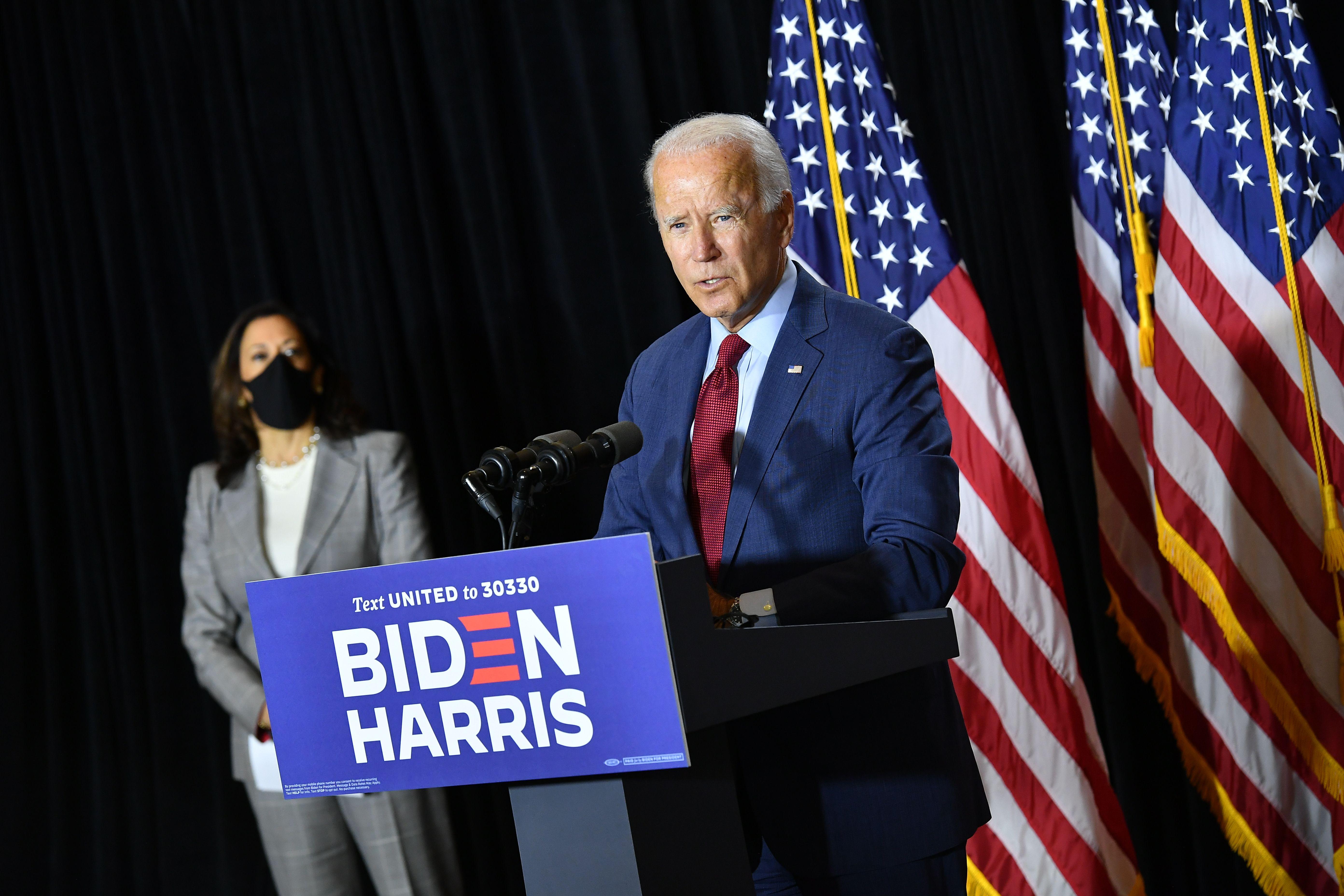 Joe Biden speaks at a podium, Harris standing beside him