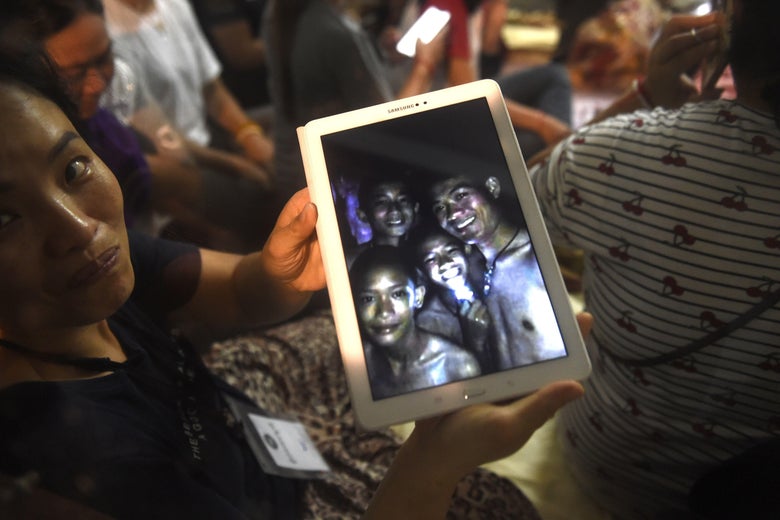 A family member shows the latest pictures of the missing boys taken by rescue divers inside Tham Luang cave.