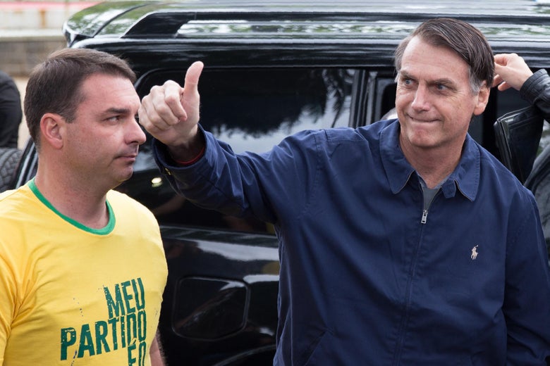 Brazil's right-wing presidential candidate Jair Bolsonaro next to his son and senate candidate Flavio Bolsonaro gives a thumb up upon arrival to vote in Rio de Janeiro, Brazil, on October 7, 2018. 