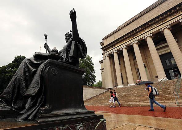 People walk past the Alma Mater statue at Columbia University.